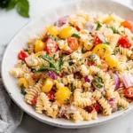 Grinder pasta salad on white platter with colorful vegetables and creamy dressing